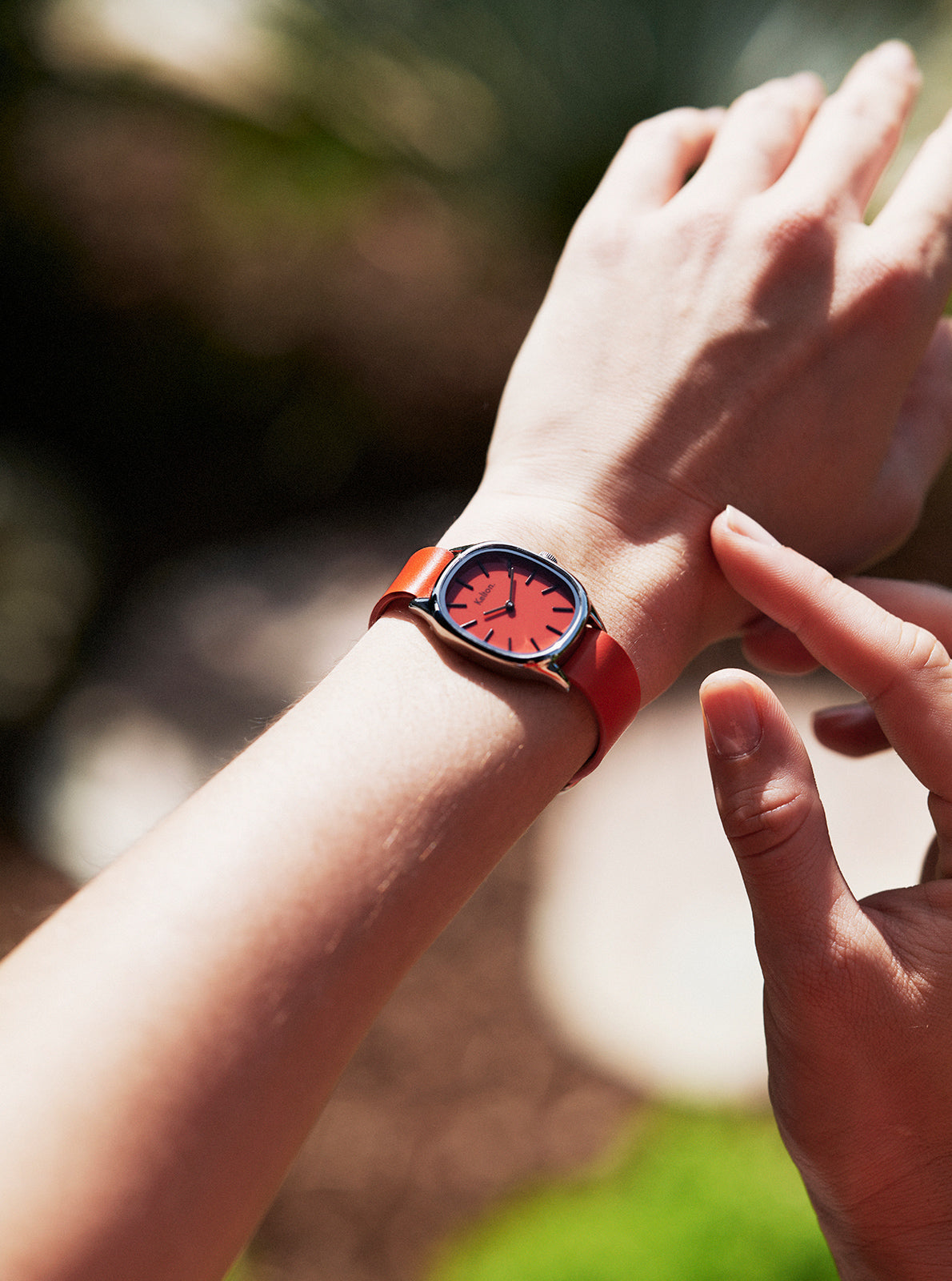 Image of Montre à bracelet orange et cadran rouge, gros plan sur le cadran