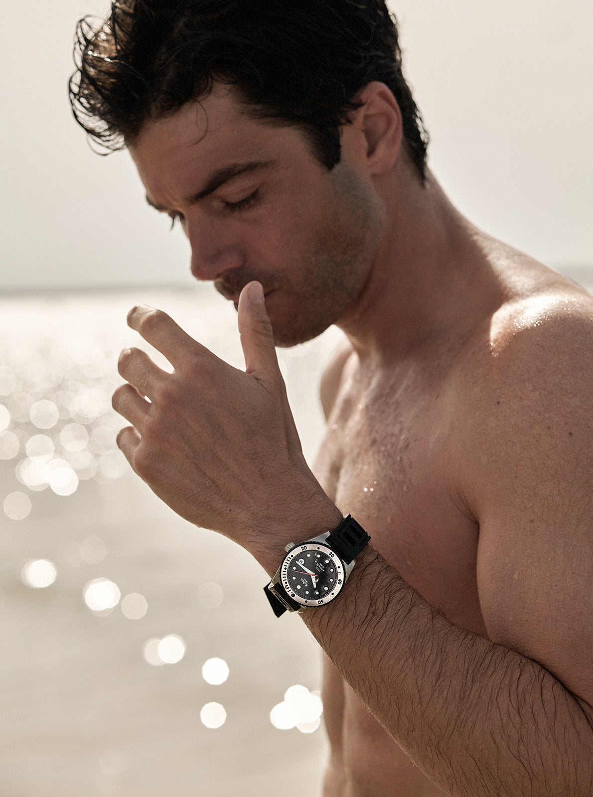 Image of Montre homme cadran noir et bracelet noir, portée au poignet, vue rapprochée