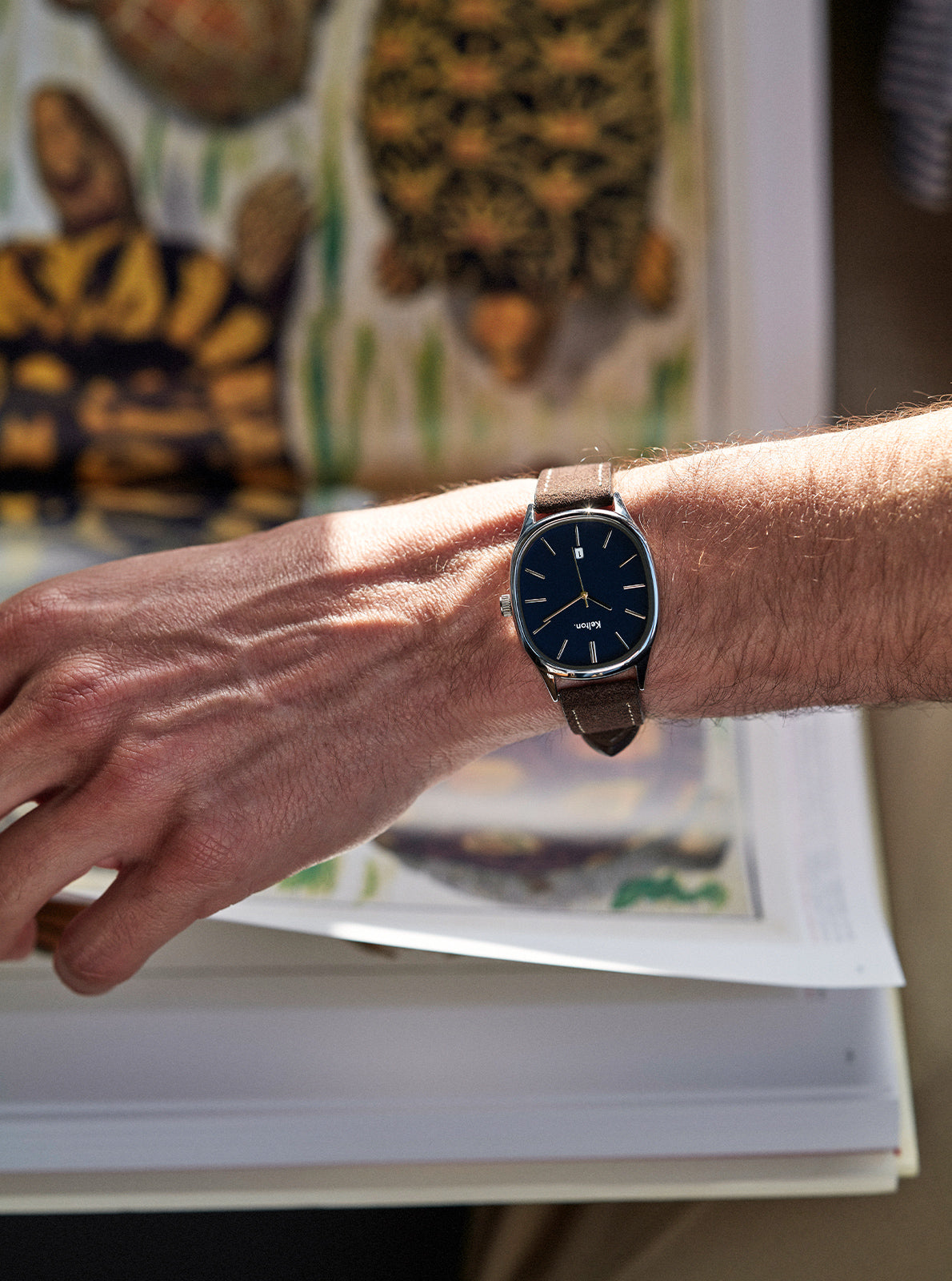 Image of Montre à cadran bleu marine, bracelet foncé, portée au poignet