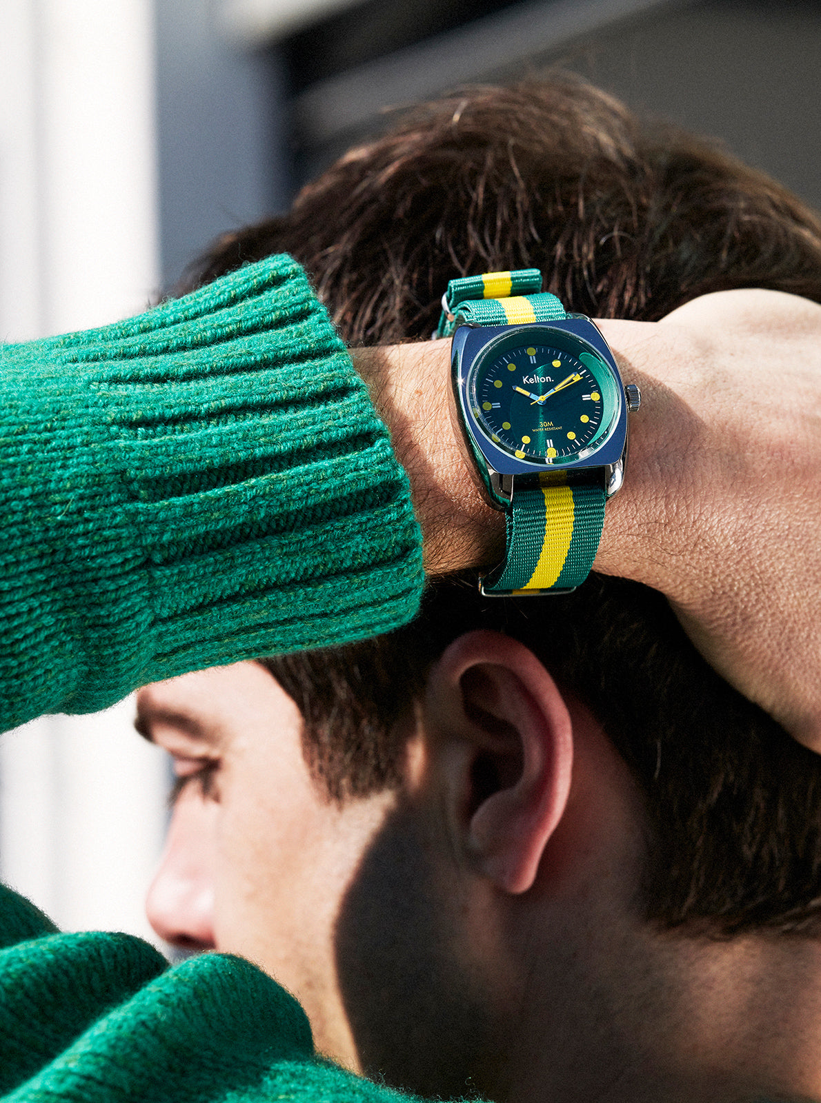 Image of Montre cadran bleu sur bracelet NATO vert et jaune, portée au poignet