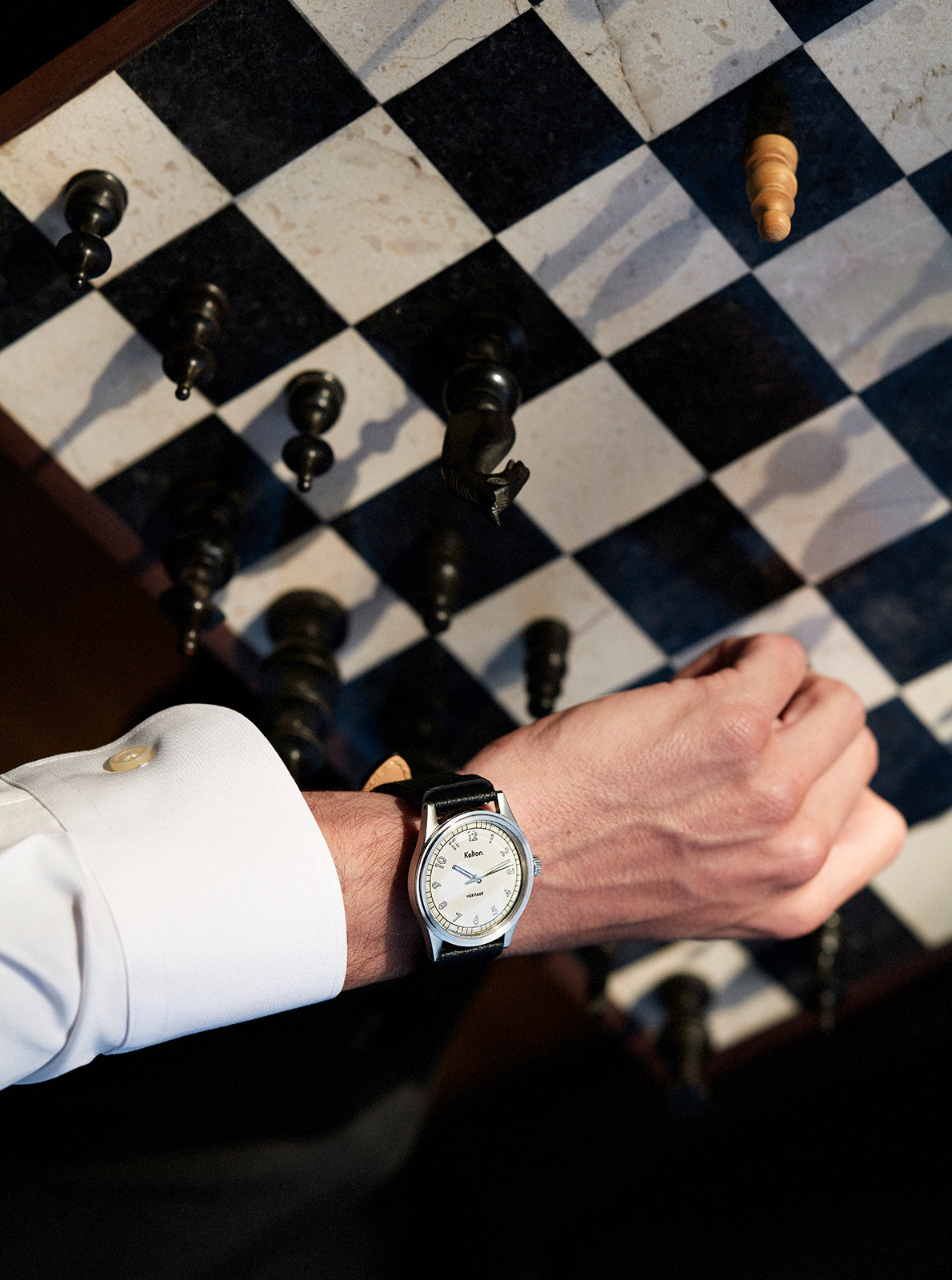 Image of Montre au poignet, cadran clair et index, bracelet cuir brun foncé, boîtier sombre