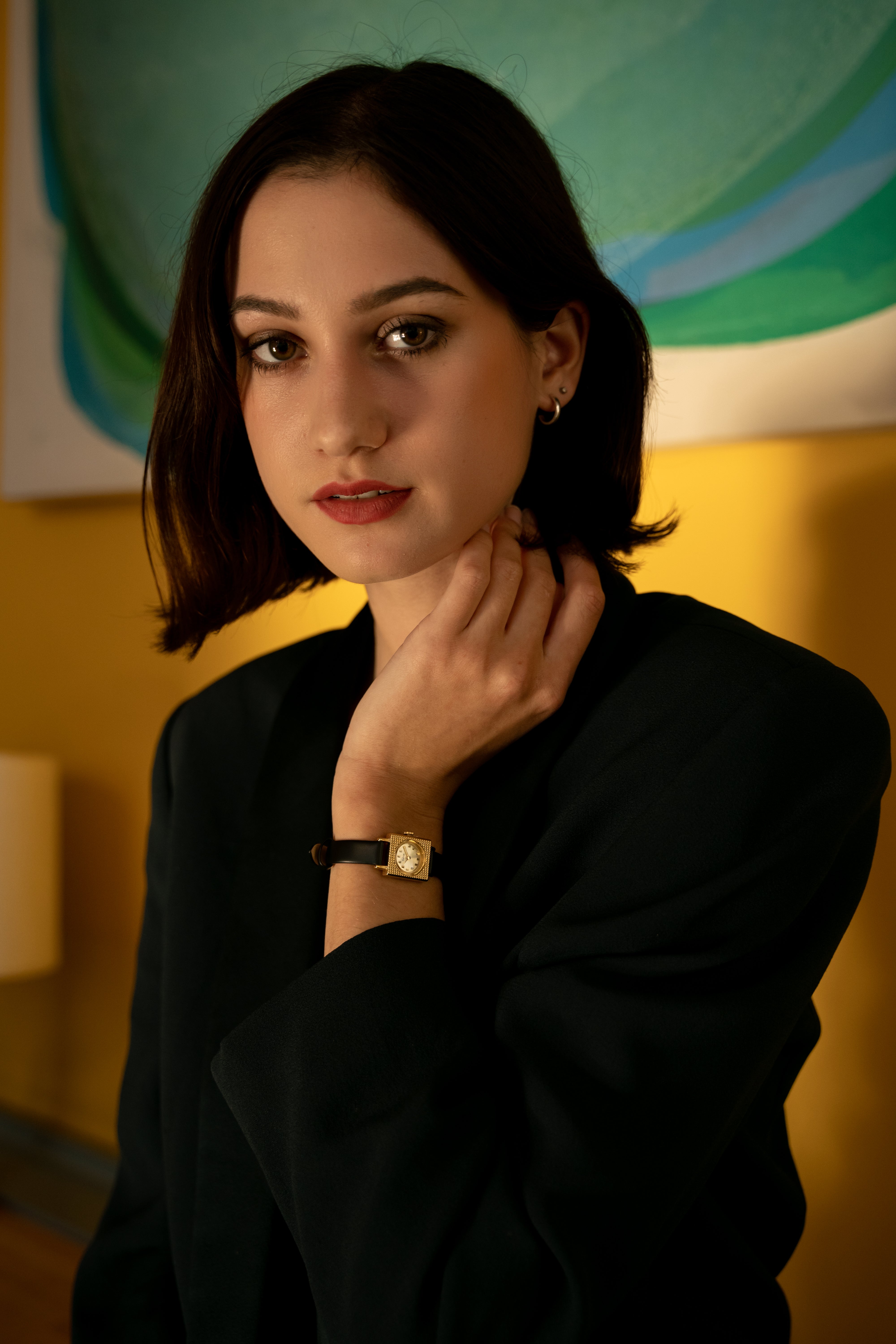 Image of Montre à cadran blanc et boîtier doré, bracelet noir, portée au poignet
