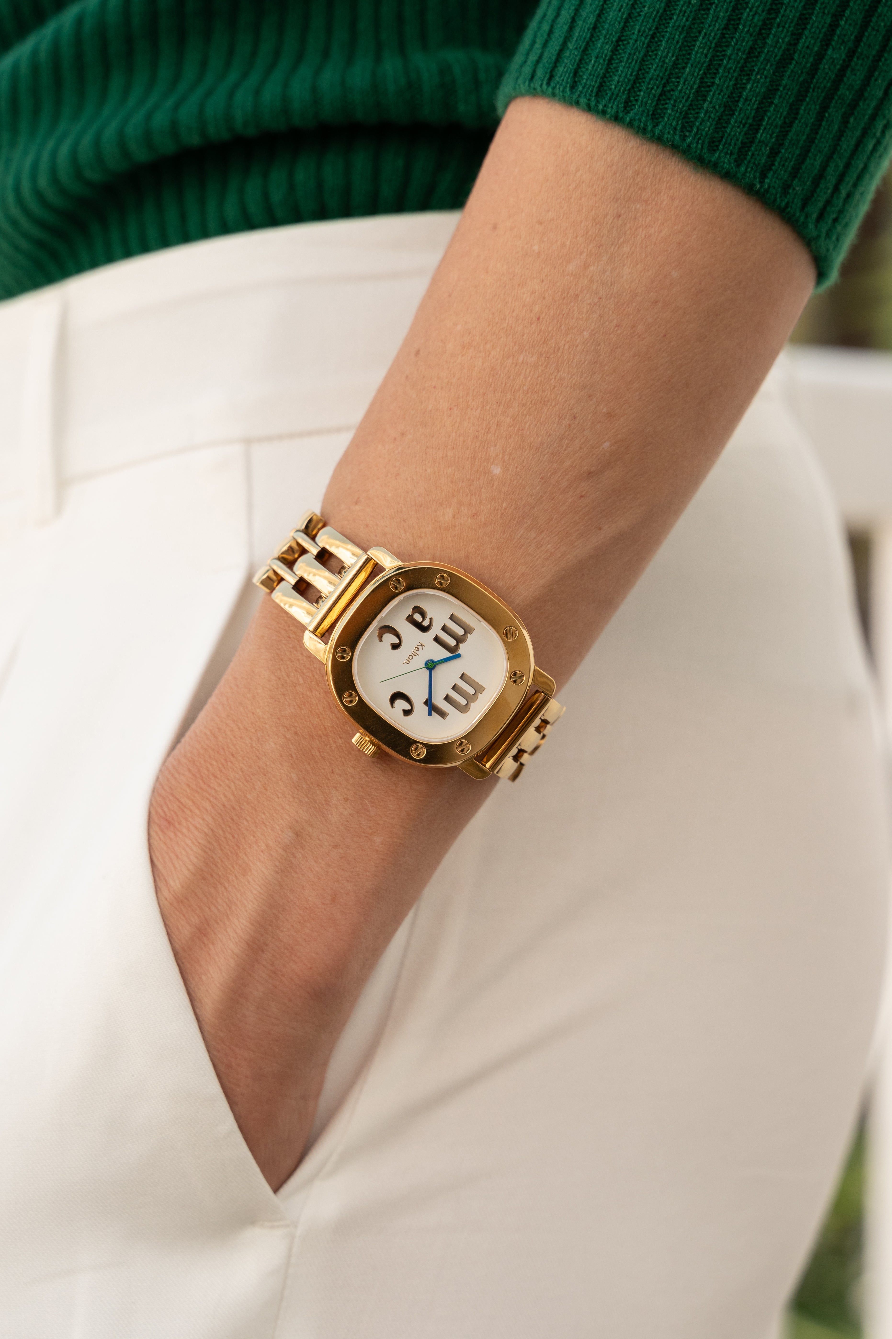 Image of Montre Kelton x Micmac St.Tropez dorée au poignet, bracelet à maillons et cadran blanc
