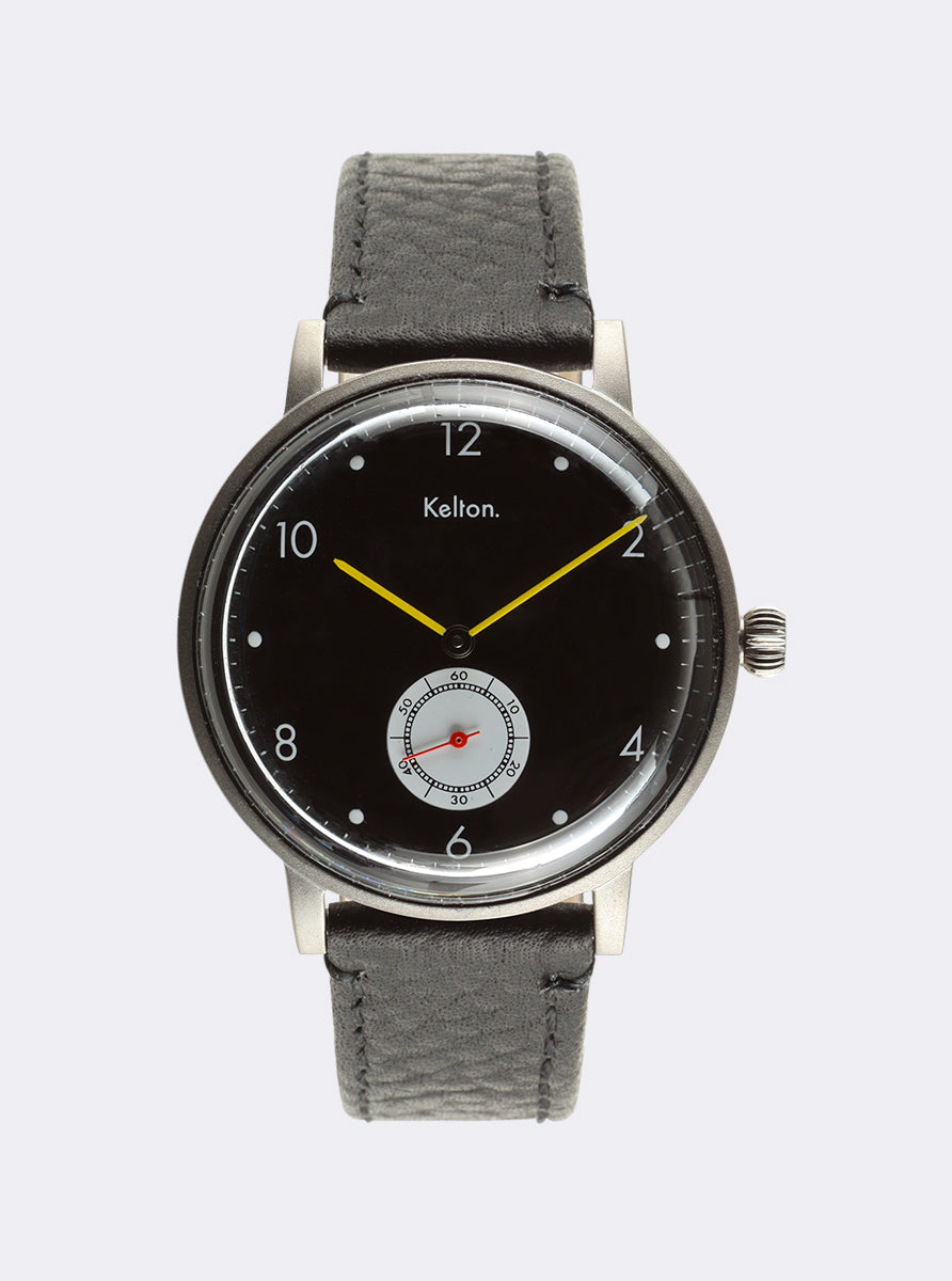 Image of Montre cadran noir, bracelet cuir noir, aiguilles jaunes et couronne latérale.