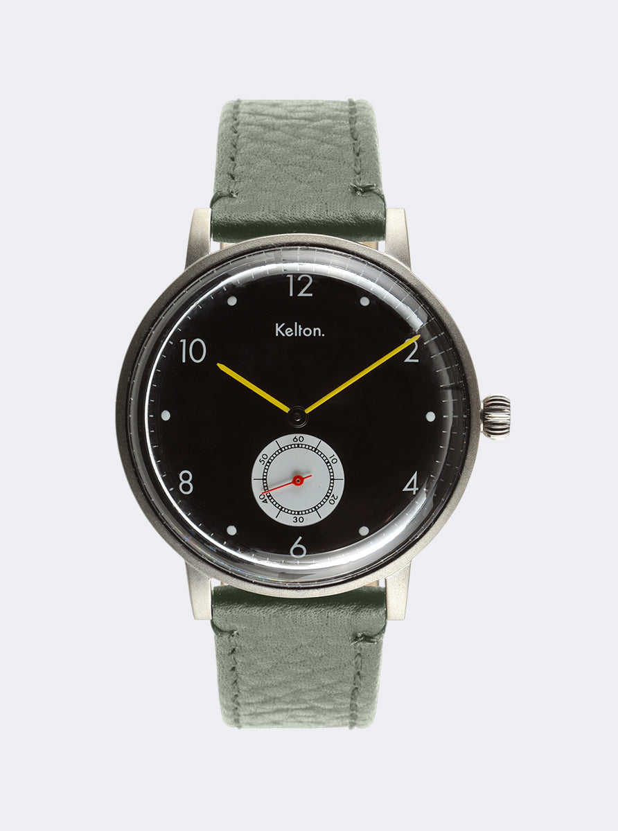 Image of Montre cadran noir, bracelet cuir vert, aiguilles jaunes et couronne latérale.