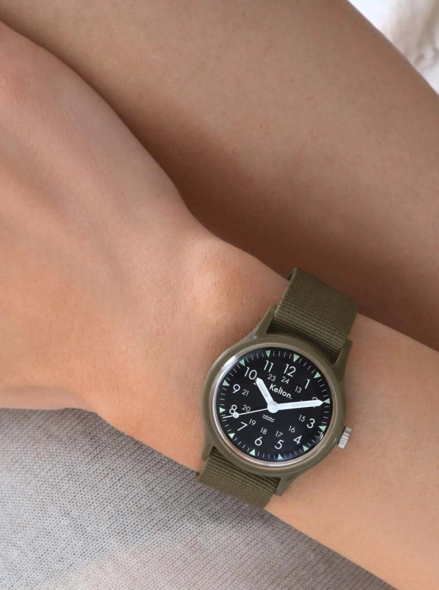 Image of Montre à bracelet tissu olive, cadran noir rond avec chiffres arabes et aiguilles