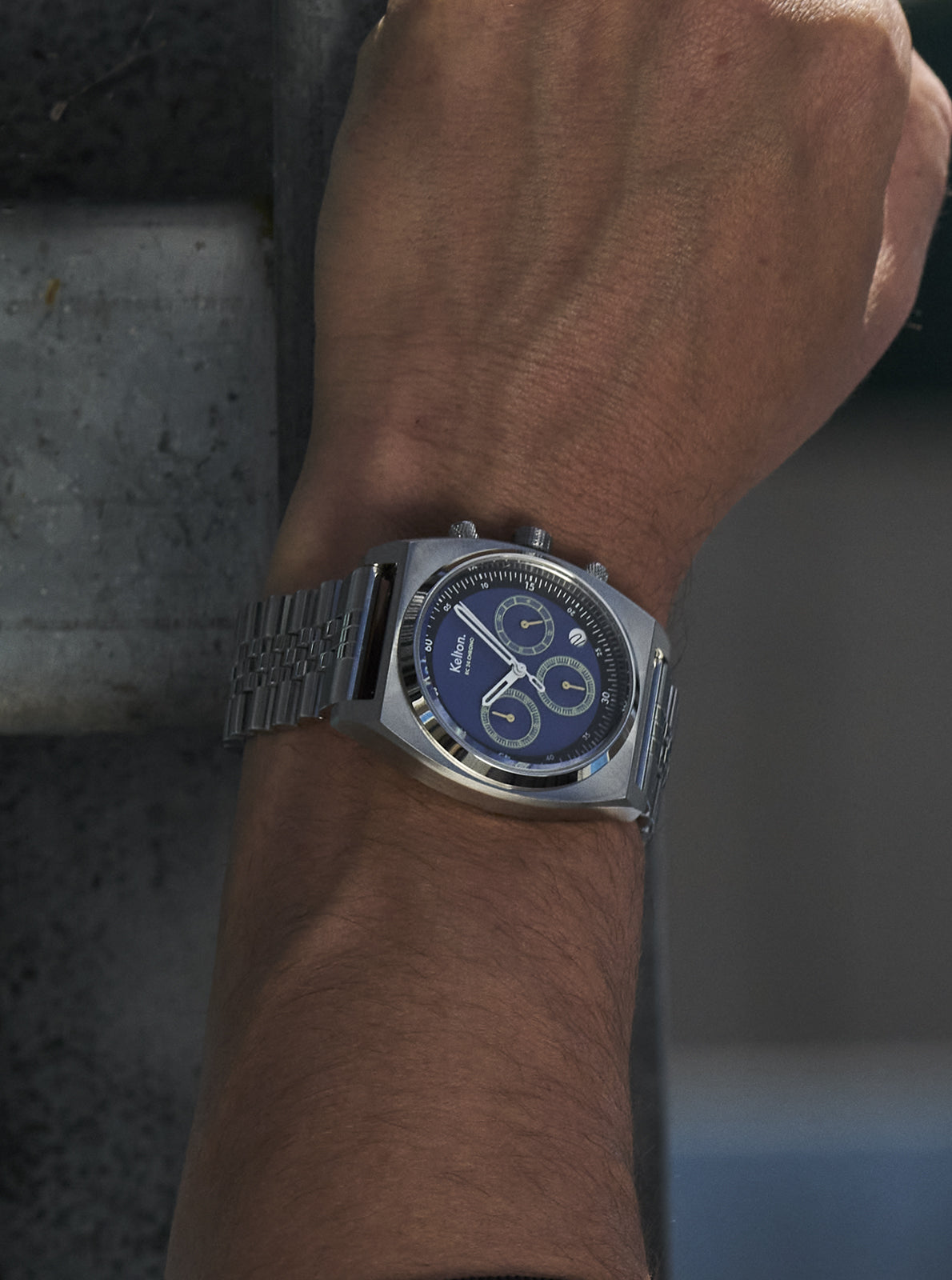 Image of Montre à bracelet métal, cadran bleu-noir et trois compteurs, portée au poignet.