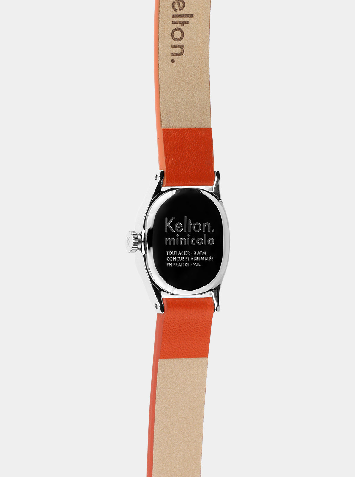 Image of Montre Kelton Minicolo cadran noir au dos, bracelet cuir mandarine et boîtier argenté rond.