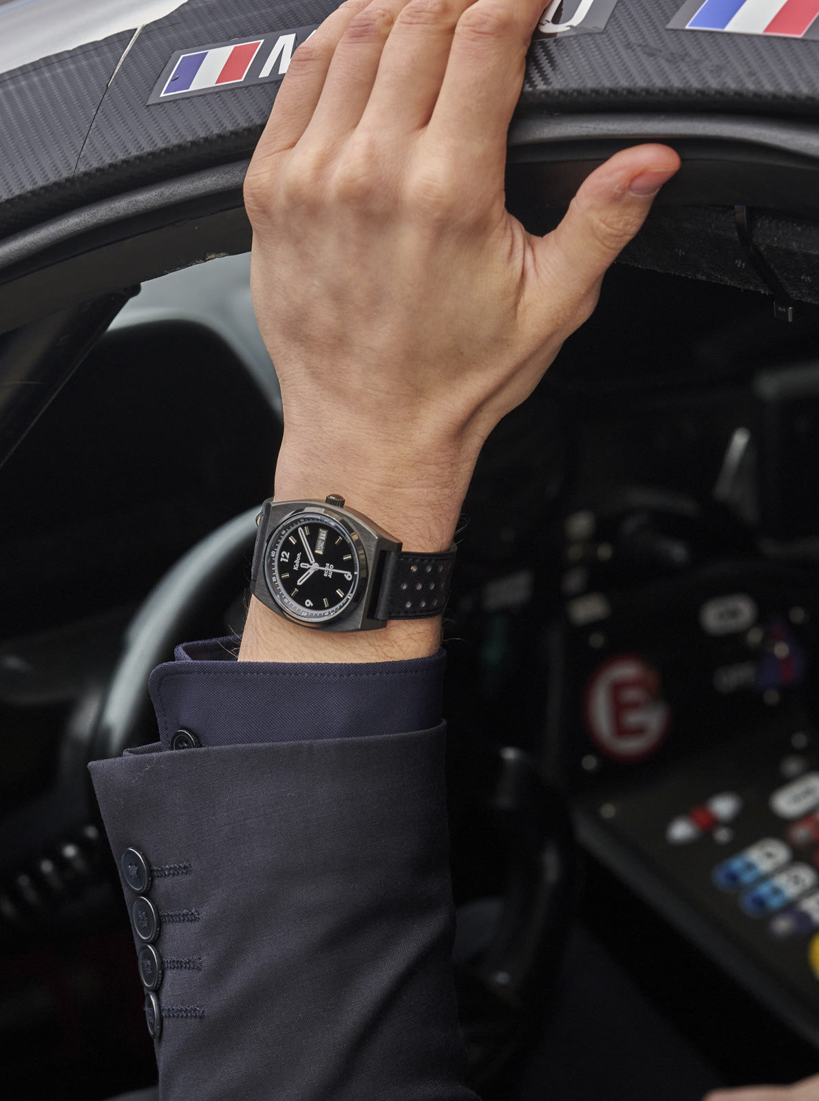 Image of Montre RC 24 noire au poignet, cadran noir et bracelet noir perforé.
