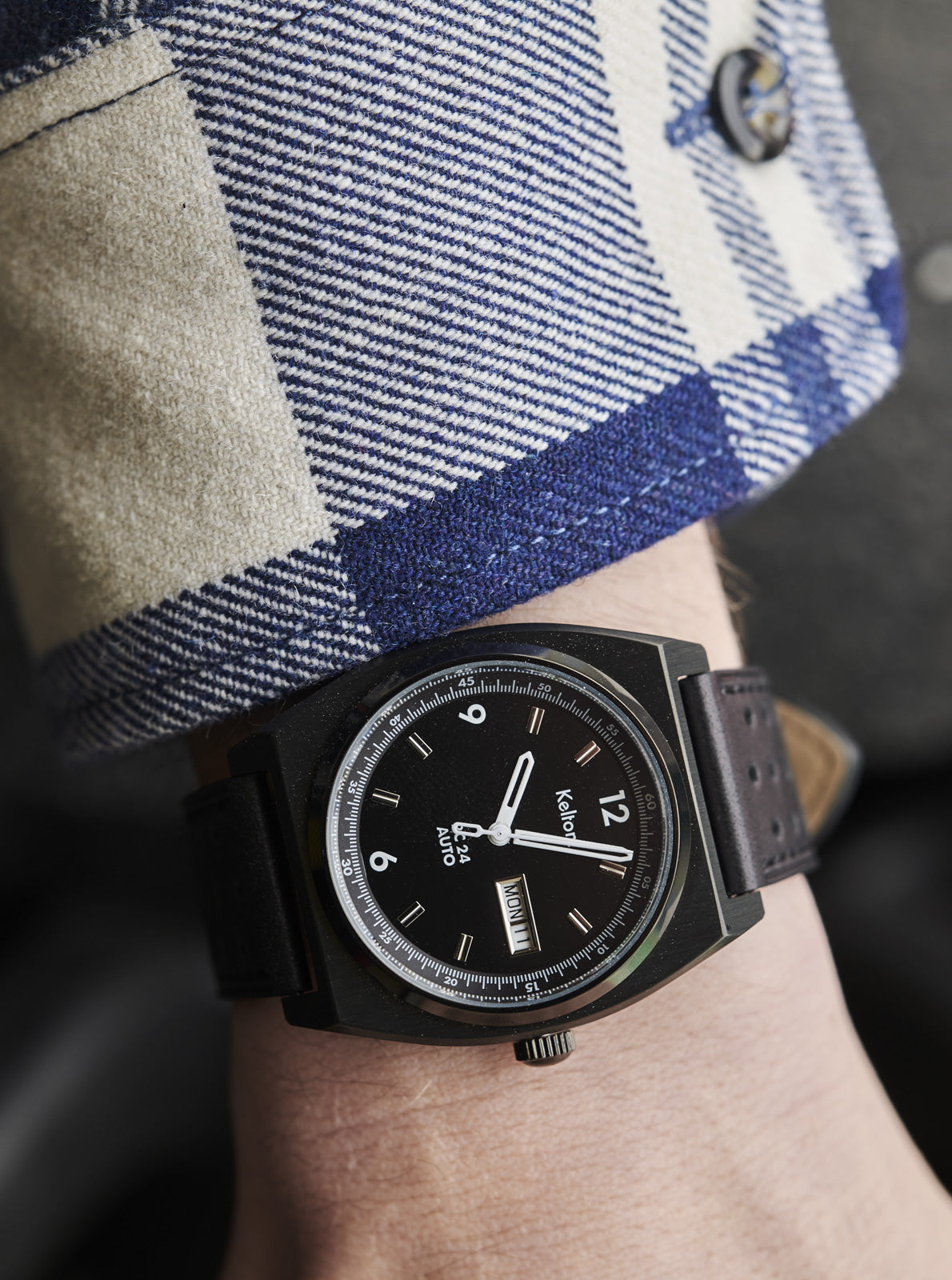 Image of Montre RC 24 noire au poignet, cadran noir et bracelet noir perforé.