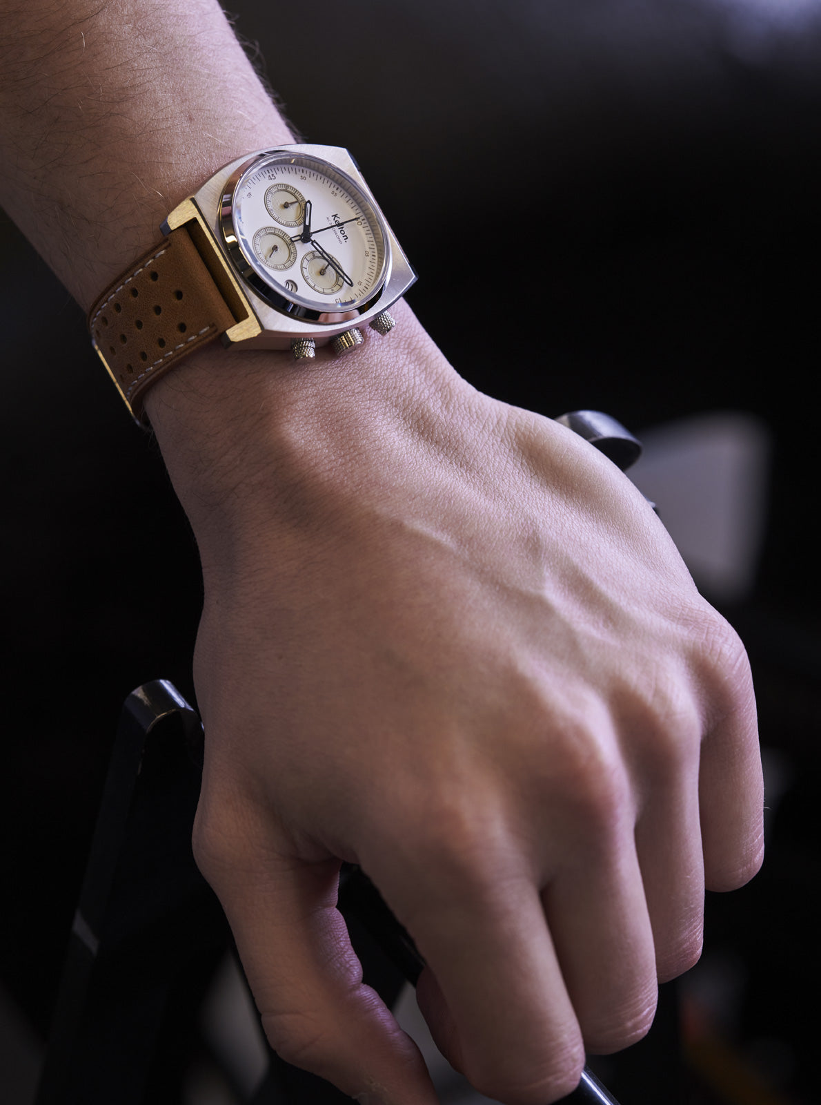 Image of Montre au poignet: cadran blanc et bracelet cuir marron perforé, vue rapprochée