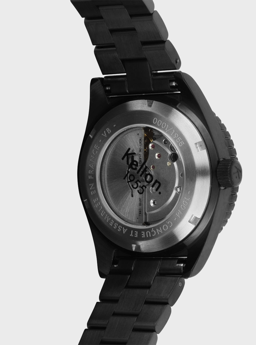 Image of Boîtier arrière de montre Kelton 1955 noire avec marquage et mécanisme visible, bracelet métal