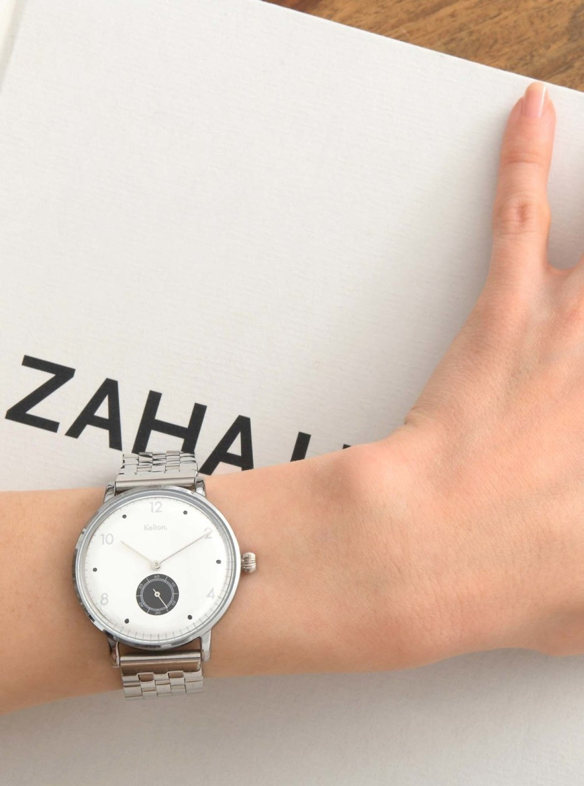 Image of Montre Villa argentée au poignet, cadran blanc et bracelet à mailles