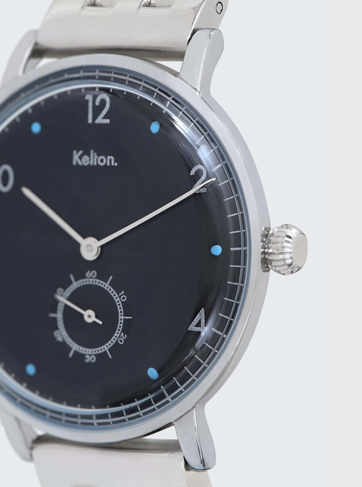 Image of Montre analogique argentée, cadran noir, couronne sur le côté et index lumineux bleus.